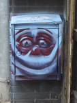 908252 Afbeelding van een graffitigezichtje op een brievenbus bij het pand Donkerstraat 4 te Utrecht.